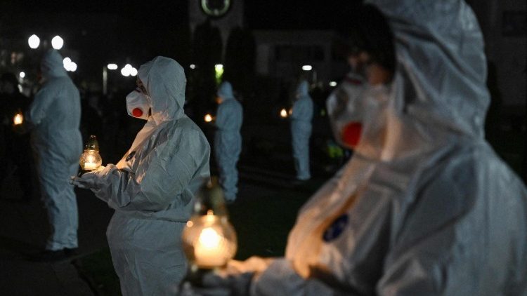Participantes vestidos com trajes de prote&ccedil;&atilde;o brancos, representando liquidadores, seguram velas durante uma cerim&ocirc;nia do 40&ordm; anivers&aacute;rio da explos&atilde;o na usina nuclear de Chernobyl, o pior desastre nuclear civil da hist&oacute;ria, em frente a um memorial para as v&iacute;timas de Chernobyl, na cidade de Slavutych, em 25 de abril de 2026, em meio &agrave; invas&atilde;o russa da Ucr&acirc;nia. (Foto de Genya SAVILOV / AFP)