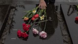 A woman touches flowers at a memorial for victims of Chernobyl in Kyiv