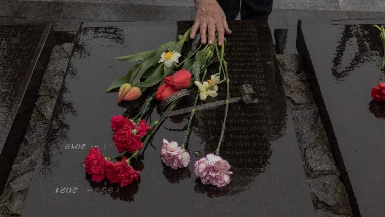 A woman touches flowers at a memorial for victims of Chernobyl in Kyiv