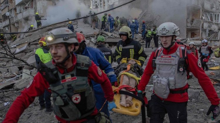 Equipes de resgate carregam uma pessoa ferida no local de um pr&eacute;dio residencial parcialmente destru&iacute;do ap&oacute;s ataques de drones e m&iacute;sseis russos em Kiev, em 14 de maio de 2026, em meio &agrave; invas&atilde;o russa da Ucr&acirc;nia. A capital ucraniana sofreu intensos ataques a&eacute;reos na madrugada de 14 de maio, conforme relatado por um jornalista da AFP, enquanto o prefeito de Kiev afirmava que a R&uacute;ssia estava atacando a cidade. (Foto de Roman PILIPEY / AFP)