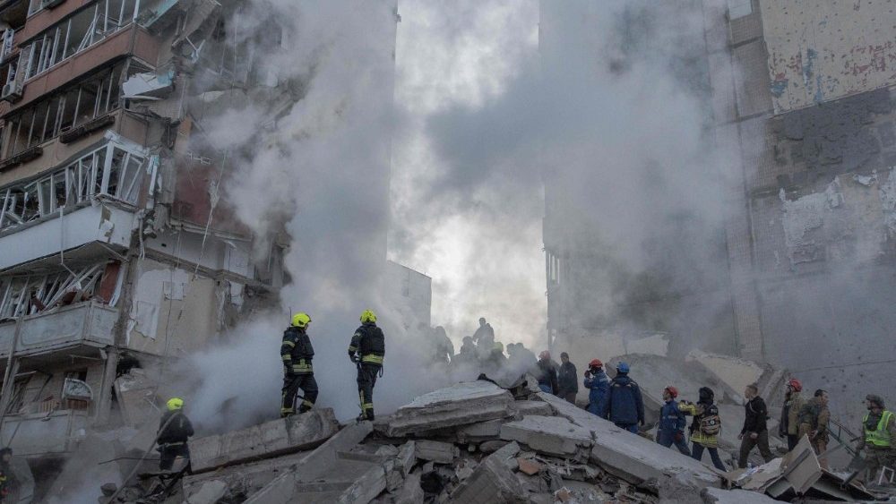 Equipes de resgate trabalham em um prédio residencial parcialmente destruído após ataques de drones e mísseis russos em Kiev, em 14 de maio de 2026, em meio à invasão russa na Ucrânia. A capital ucraniana sofreu um intenso ataque aéreo no início da manhã de 14 de maio, conforme relatado por um jornalista da AFP, enquanto o prefeito de Kiev afirmava que a Rússia estava atacando a cidade. (Foto de Roman PILIPEY / AFP)