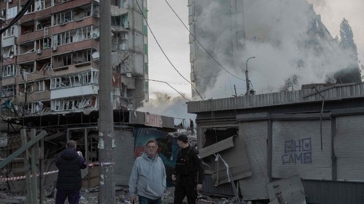 Pessoas observam um pr&eacute;dio residencial parcialmente destru&iacute;do ap&oacute;s ataques de drones e m&iacute;sseis russos em Kiev, em 14 de maio de 2026, em meio &agrave; invas&atilde;o russa na Ucr&acirc;nia. A capital ucraniana sofreu um intenso ataque a&eacute;reo no in&iacute;cio da manh&atilde; de 14 de maio, conforme relatado por um jornalista da AFP, enquanto o prefeito de Kiev afirmava que a R&uacute;ssia estava atacando a cidade. (Foto de Roman PILIPEY / AFP)