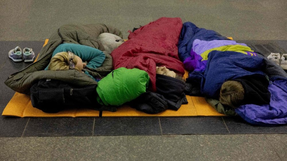 Moradores locais dormem em sacos de dormir durante um alerta aéreo, buscando abrigo em uma estação de metrô em Kiev, em 14 de maio de 2026, em meio à invasão russa na Ucrânia. A capital ucraniana sofreu intensos ataques aéreos na madrugada de 14 de maio, conforme relatado por um jornalista da AFP, enquanto o prefeito de Kiev afirmava que a Rússia estava bombardeando a cidade. (Foto de Tetiana Dzhafarova / AFP)
