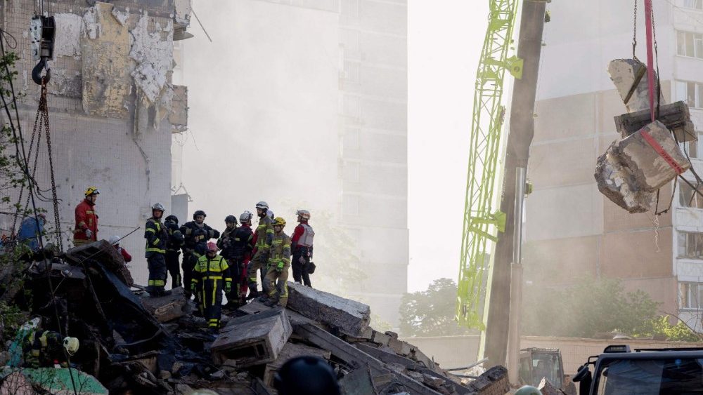 Equipes de resgate e socorristas atuam no local de um prédio residencial parcialmente destruído após ataques de drones e mísseis russos em Kiev, em 14 de maio de 2026, em meio à invasão russa da Ucrânia. (Foto de Tetiana DZHAFAROVA / AFP)