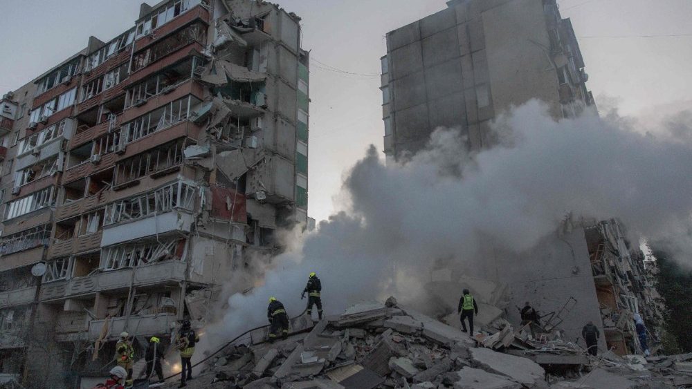 Equipes de resgate trabalham em um prédio residencial parcialmente destruído após ataques de drones e mísseis russos em Kiev, em 14 de maio de 2026, em meio à invasão russa na Ucrânia. A capital ucraniana sofreu um intenso ataque aéreo no início da manhã de 14 de maio, conforme relatado por um jornalista da AFP, enquanto o prefeito de Kiev afirmava que a Rússia estava atacando a cidade. (Foto de Roman PILIPEY / AFP)