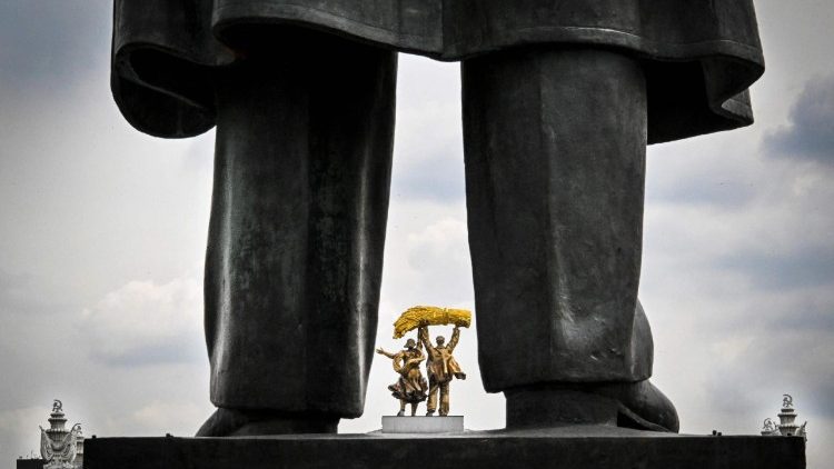 Parte do monumento ao fundador da União Soviética, Vladimir Lenin, é vista em frente a um conjunto de esculturas na entrada principal do Centro de Exposições de Toda a Rússia (VDNKh) em Moscou, em 14 de maio de 2026. (Foto de Alexander Nemenov / AFP)