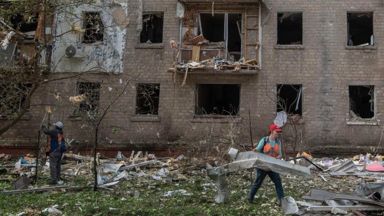 Trabalhadores comunit&aacute;rios limpam os destro&ccedil;os no p&aacute;tio de um pr&eacute;dio residencial danificado ap&oacute;s um ataque a&eacute;reo em Dnipro, em 18 de maio de 2026, em meio &agrave; invas&atilde;o russa da Ucr&acirc;nia. A R&uacute;ssia lan&ccedil;ou centenas de drones e quase duas dezenas de m&iacute;sseis contra a Ucr&acirc;nia durante a noite, ferindo mais de 30 pessoas, enquanto Kiev e Moscou intensificam os ataques mortais de longo alcance, anunciaram autoridades ucranianas. (Foto de Mykola Synelnykov / AFP)