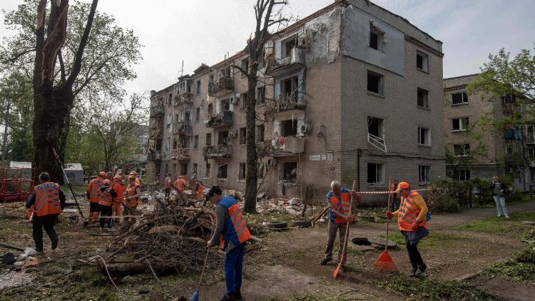 Municipal workers clean debris in the courtyard of a damaged residential building following an air attack in Dnipro on May 18, 2026, amid the Russian invasion of Ukraine. Russia launched hundreds of drone and nearly two dozen missiles at Ukraine overnight wounding more than 30 people, as Kyiv and Moscow step up deadly long-range attacks, Ukrainian officials announced. (Photo by Mykola SYNELNYKOV / AFP)