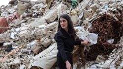 A woman stands on the rubble of her house in Beirut after an Israeli strike that killed her parents