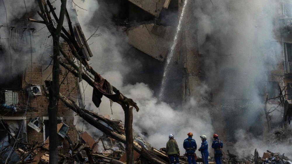 Equipes de resgate trabalham no local de um prédio gravemente danificado enquanto a fumaça sobe após ataques russos em Kiev, em 24 de maio de 2026, em meio à invasão russa da Ucrânia. Um grande ataque com mísseis balísticos atingiu Kiev na madrugada de 24 de maio, disseram as autoridades, ferindo pelo menos cinco pessoas, depois que Moscou ameaçou retaliar pelos ataques no leste da Ucrânia, ocupado pela Rússia. (Foto de OLEKSII FILIPPOV / AFP)