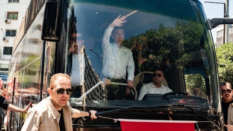 Özgür Özel (au centre), ancien dirigeant du Parti républicain du peuple (CHP) turc, saluant ses partisans à son arrivée en bus lors d'un rassemblement à Izmir, le 26 mai 2026, quelques jours après sa destitution par un tribunal.