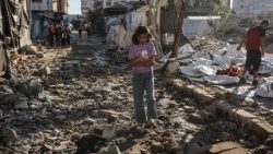 Una bambina palestinese cammina tra le macerie di Gaza City
