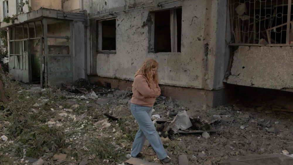 Uma mulher caminha entre os escombros do lado de fora de um prédio residencial de vários andares que foi danificado após ataques com mísseis e drones russos em Kiev, em 2 de junho de 2026, durante a invasão russa da Ucrânia. A Rússia disparou mais de 600 drones e dezenas de mísseis — incluindo mísseis balísticos de difícil abate — contra a Ucrânia, informou a Força Aérea de Kiev em 2 de junho de 2026, em um bombardeio noturno que matou pelo menos nove pessoas. (Foto de Roman PILIPEY / AFP)