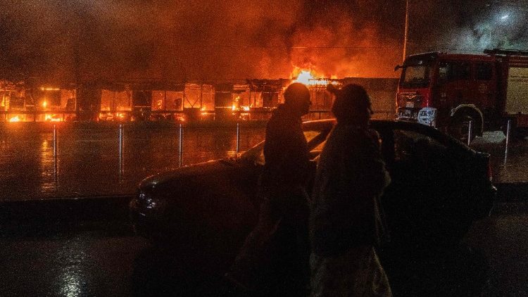 Moradores caminham em frente a um mercado em chamas ap&oacute;s um ataque de m&iacute;sseis russos em Kiev, em 15 de junho de 2026, em meio &agrave; invas&atilde;o russa na Ucr&acirc;nia. A R&uacute;ssia disparou uma s&eacute;rie de m&iacute;sseis contra v&aacute;rias das principais cidades ucranianas, incendiando a hist&oacute;rica Catedral da Dormi&ccedil;&atilde;o de Kiev e matando nove pessoas, enquanto ataques na Ucr&acirc;nia deixaram tr&ecirc;s mortos ao sul de Moscou. (Foto de OLEKSII FILIPPOV / AFP)