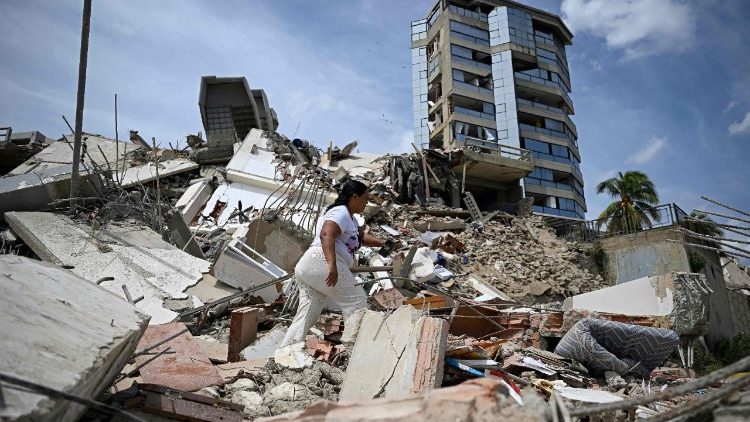 A woman searches through the rubble of a collapse building