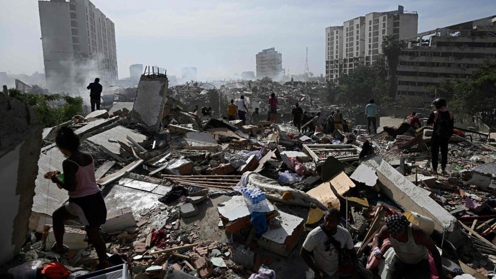 Moradores caminham em meio aos escombros após um terremoto duplo em Caraballeda, estado de La Guaira, a cerca de 40 km a nordeste de Caracas, em 25 de junho. (Foto de Federico Parra / AFP