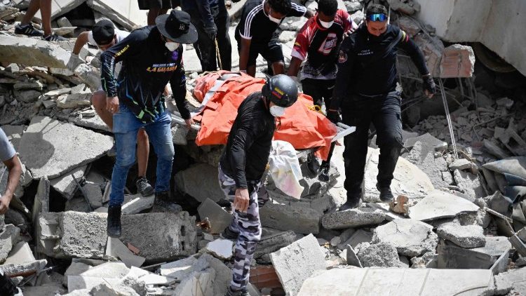Miembros y voluntarios de Protección Civil de Venezuela recuperan un cadáver en el lugar donde se derrumbaron varios edificios tras los terremotos ocurridos en Caraballeda, en el estado de La Guaira (Venezuela)