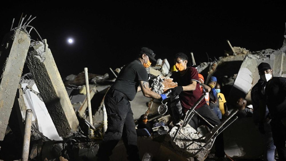 Pessoas procuram por seus parentes falecidos entre os escombros de um prédio que desabou no bairro de Los Corales, em Caraballeda, estado de La Guaira, Venezuela, em 1º de julho de 2026, após os terremotos gêmeos de 24 de junho. A esperança de encontrar mais sobreviventes diminuiu em 1º de julho, quando a Venezuela completou uma semana desde que os terremotos gêmeos mataram quase 2.300 pessoas, enquanto muitos que sobreviveram ao desastre enfrentavam uma grave escassez de alimentos. (Foto de Federico Parra / AFP)