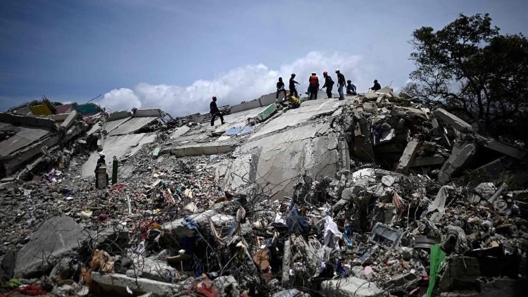Bomberos y trabajadores de rescate operan entre los escombros de edificios derrumbados tras los terremotos del 24 de junio en Catia La Mar, estado de La Guaira, Venezuela, el 8 de julio de 2026.