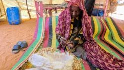 Eine Frau im Sudan, die Bohnen schält