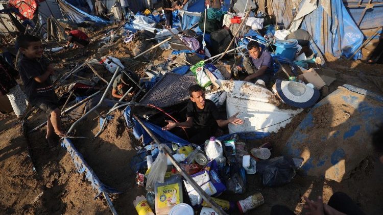 Un palestinese sfollato seduto tra i resti della sua tenda dopo il raid aereo israeliano che ha colpito il magazzino di forniture mediche e farmaceutiche dell'ospedale dei martiri di Al-Aqsa, a Deir al-Balah, nella Striscia di Gaza, il primo agosto