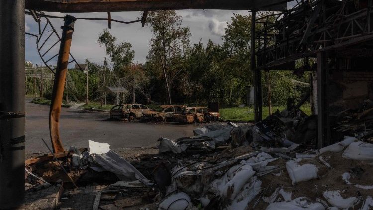 Esta fotografia mostra um posto de gasolina e carros destru&iacute;dos num ataque a&eacute;reo russo na cidade de Izium, na regi&atilde;o leste de Kharkiv, em 29 de julho de 2026, durante a invas&atilde;o russa da Ucr&acirc;nia. (Foto de Roman PILIPEY / AFP)