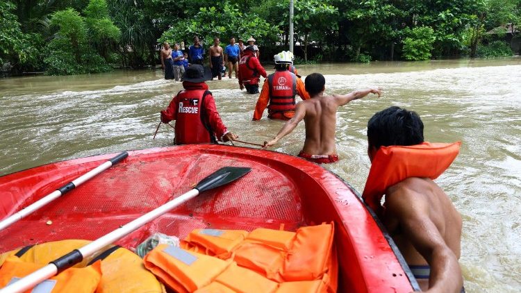 Soccorritori e vigili del fuoco si fanno strada tra le acque allagate di un monastero a Lemyethna, nella regione dell'Irrawaddy