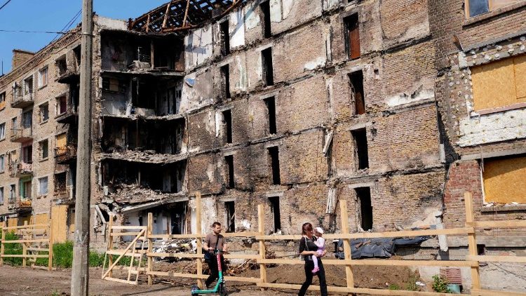 Um casal e uma crian&ccedil;a caminham em frente a um pr&eacute;dio de apartamentos gravemente danificado ap&oacute;s ataques russos no distrito de Lukianivska, em Kiev, em 5 de agosto de 2026, durante a visita de um dia do Secret&aacute;rio de Defesa brit&acirc;nico &agrave; capital ucraniana. O Reino Unido anunciou um investimento de &pound; 8,4 bilh&otilde;es (US$ 11,2 bilh&otilde;es) para a pr&oacute;xima fase de seu programa de submarinos nucleares da classe Dreadnought, que, segundo o governo, viabilizar&aacute; 22.000 est&aacute;gios na pr&oacute;xima d&eacute;cada. (Foto de Jane Barlow / POOL / AFP)