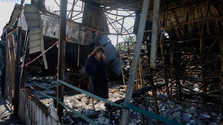 Uma mulher observa objetos de cer&acirc;mica queimados e quebrados em um mercado de rua danificado ap&oacute;s ataques russos no bairro de Petrivka, em Kiev, em 9 de agosto de 2026, em meio &agrave; invas&atilde;o russa da Ucr&acirc;nia. (Foto de Tetiana DZHAFAROVA / AFP)