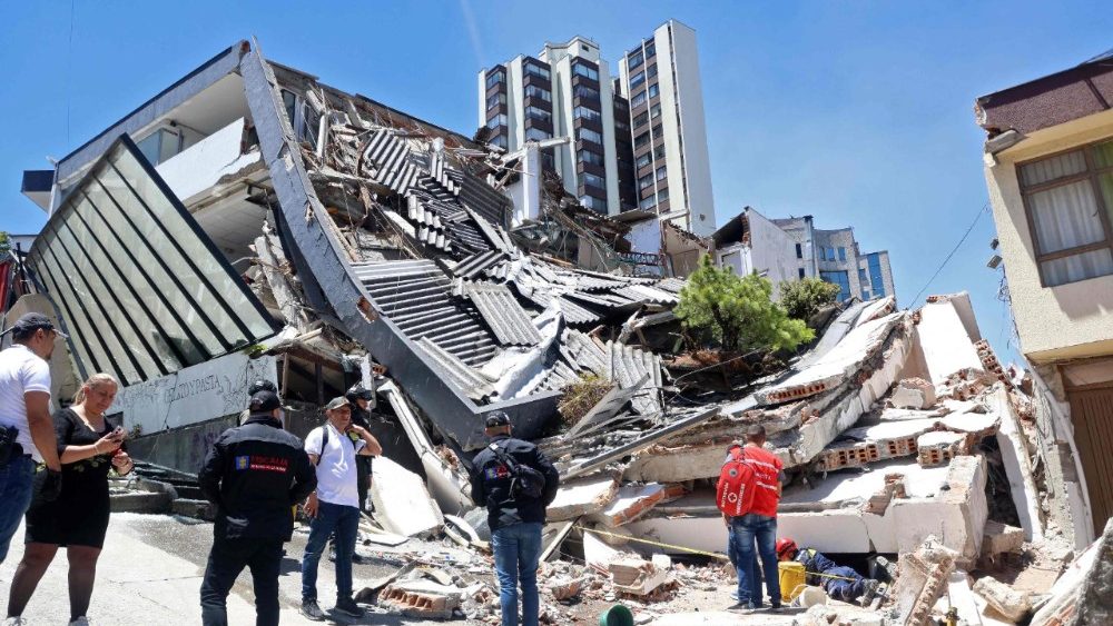 Pessoas permanecem perto de um prédio desabado após um terremoto em Manizales, Colômbia, em 10 de agosto de 2026. Um forte terremoto atingiu a Colômbia e países vizinhos da América Latina em 10 de agosto de 2026, com equipes médicas correndo para ajudar as vítimas após prédios serem danificados ou desabarem em diversas cidades. O Serviço Geológico da Colômbia e seu equivalente americano, o USGS, registraram a magnitude em 7,4, com epicentro a 100 km de profundidade no oeste do país. Inicialmente, a Colômbia havia estimado a magnitude em 6,6. (Foto de Giovanny Galvez / AFP)