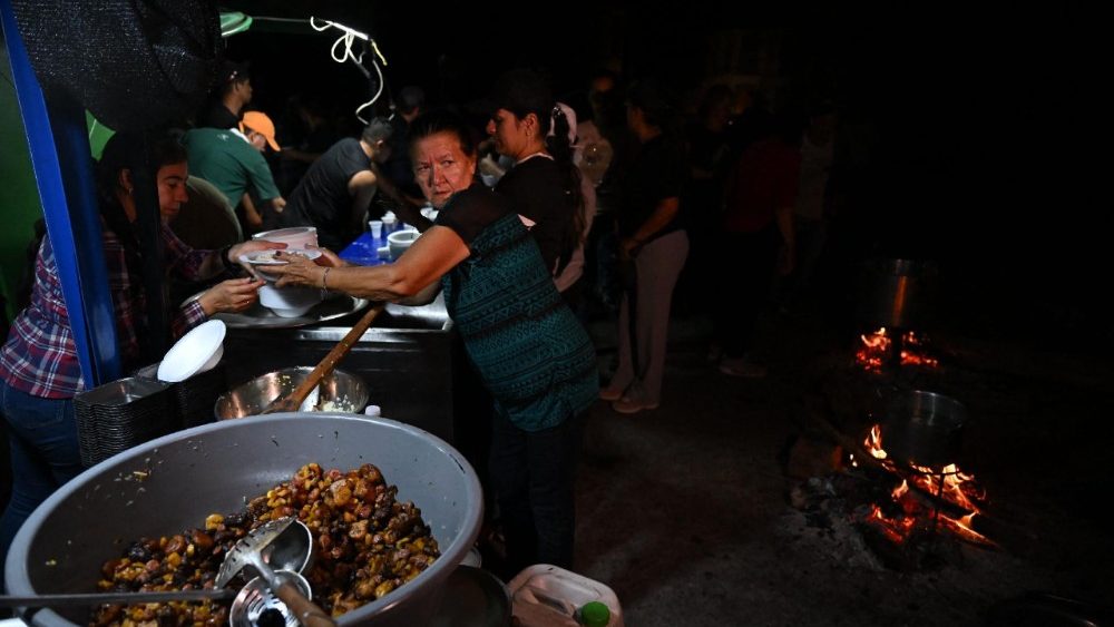 Sobreviventes se reúnem em torno de alimentos durante um blecaute após um terremoto em El Cairo, Valle del Cauca, Colômbia, em 11 de agosto de 2026. Equipes de resgate, soldados e voluntários vasculharam blocos de apartamentos e edifícios de escritórios desabados em todo o oeste da Colômbia, correndo para encontrar sobreviventes depois que o terremoto mais forte do país em um século matou pelo menos 241 pessoas e deixou muitas outras desabrigadas. (Foto de Raul ARBOLEDA/AFP)