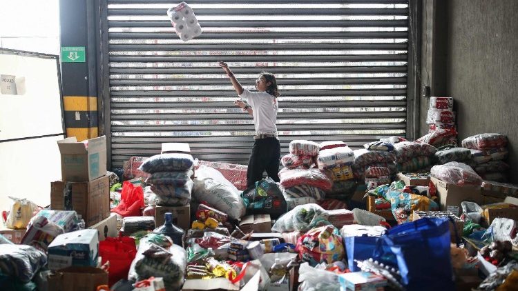 Um membro da Cruz Vermelha colombiana re&uacute;ne ajuda para as v&iacute;timas do terremoto em Bogot&aacute;, em 11 de agosto de 2026. Volunt&aacute;rios e socorristas colombianos removeram os escombros com as pr&oacute;prias m&atilde;os em busca de sobreviventes na madrugada de 11 de agosto, ap&oacute;s o terremoto mais forte no pa&iacute;s em uma d&eacute;cada ter matado pelo menos 169 pessoas e destru&iacute;do dezenas de pr&eacute;dios. (Foto de ESTEBAN VEGA LA-ROTTA / AFP)