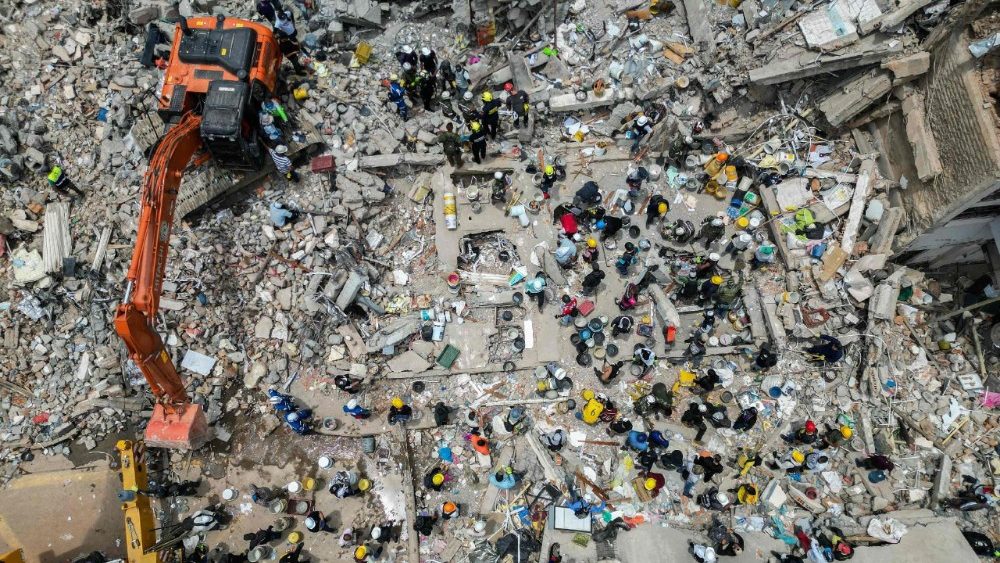 Esta vista aérea mostra máquinas pesadas usadas por equipes de resgate na busca por sobreviventes em meio aos escombros de um prédio que desabou após um terremoto em Pereira, Colômbia, em 12 de agosto de 2026. Equipes de resgate, soldados e voluntários vasculharam prédios de apartamentos e escritórios que desabaram em toda a região oeste da Colômbia, numa corrida contra o tempo para encontrar sobreviventes após o terremoto mais forte do século no país, que matou pelo menos 239 pessoas e deixou muitas outras desabrigadas em 10 de agosto de 2026. O terremoto de magnitude 7,4 feriu mais de 1.670 pessoas, segundo dados das autoridades municipais. (Foto de Luis ACOSTA / AFP)