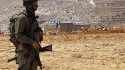 Un soldat israélien se tient devant une maison réquisitionnée par des colons israéliens à Beit Sahour, au sud de Bethléem, en Cisjordanie, le 14 août 2026. 