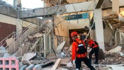 Les secouristes inspectent un bâtiment effondré à Maumere, dans la province de Nusa Tenggara oriental, en Indonésie.