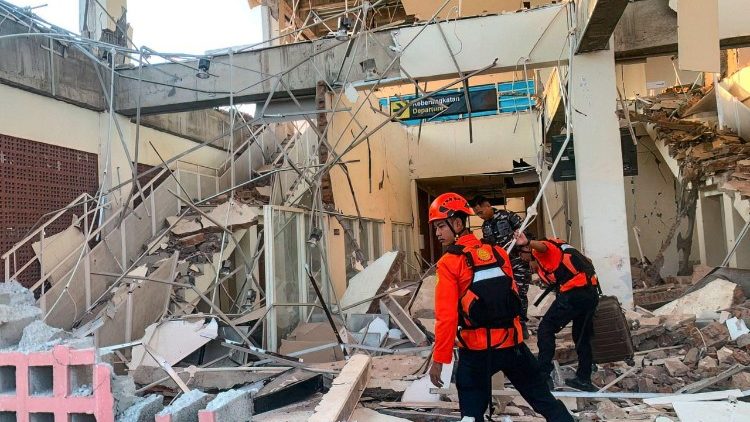 Les secouristes inspectent un bâtiment effondré à Maumere, dans la province de Nusa Tenggara oriental, en Indonésie.
