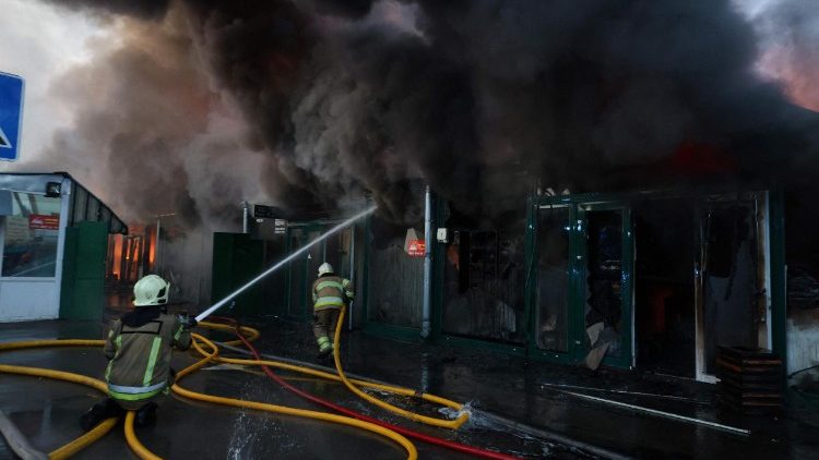 Equipes de resgate ucranianas usam uma mangueira para apagar um inc&ecirc;ndio no local de um ataque russo em Kiev, em 16 de agosto de 2026, durante a invas&atilde;o russa da Ucr&acirc;nia. Os ataques russos mataram uma pessoa e feriram pelo menos outras sete na Ucr&acirc;nia, disseram as autoridades em 16 de agosto, enquanto autoridades de Moscou relataram ter abatido mais de 100 drones que se dirigiam para a capital. (Foto: AFP)
