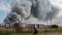 Un dipendente di Wildberries passa accanto a una colonna di fumo che si alza durante un incendio nel complesso logistico dell'azienda russa di e-commerce Wildberries, vicino alla città di Podolsk, alle porte di Mosca