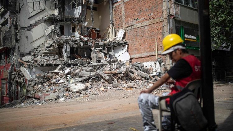 Um homem descansa em frente a um pr&eacute;dio desabado ap&oacute;s o terremoto de magnitude 7,4 em Pereira, departamento de Risaralda, Col&ocirc;mbia, em 23 de agosto de 2026. O poderoso terremoto que matou centenas de pessoas no oeste da Col&ocirc;mbia causou preju&iacute;zos econ&ocirc;micos de US$ 9,57 bilh&otilde;es, disse o presidente Abelardo de la Espriella em 18 de agosto, ao divulgar uma estimativa preliminar. (Foto de Esteban Vega La-Rotta / AFP)