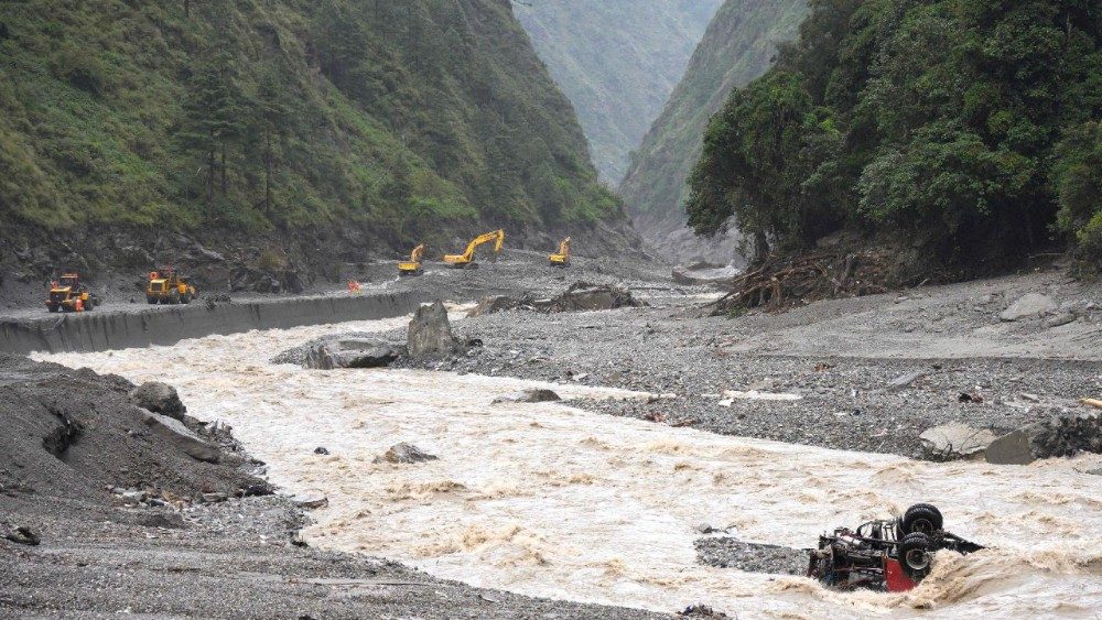 Escavadeiras trabalham para reparar um trecho da estrada que leva ao porto de Gyirong, danificado por um deslizamento de terra ocorrido dois dias antes, no condado de Gyirong, na região do Tibete Ocidental, na China, em 28 de agosto de 2026. (Foto: CNS/AFP)