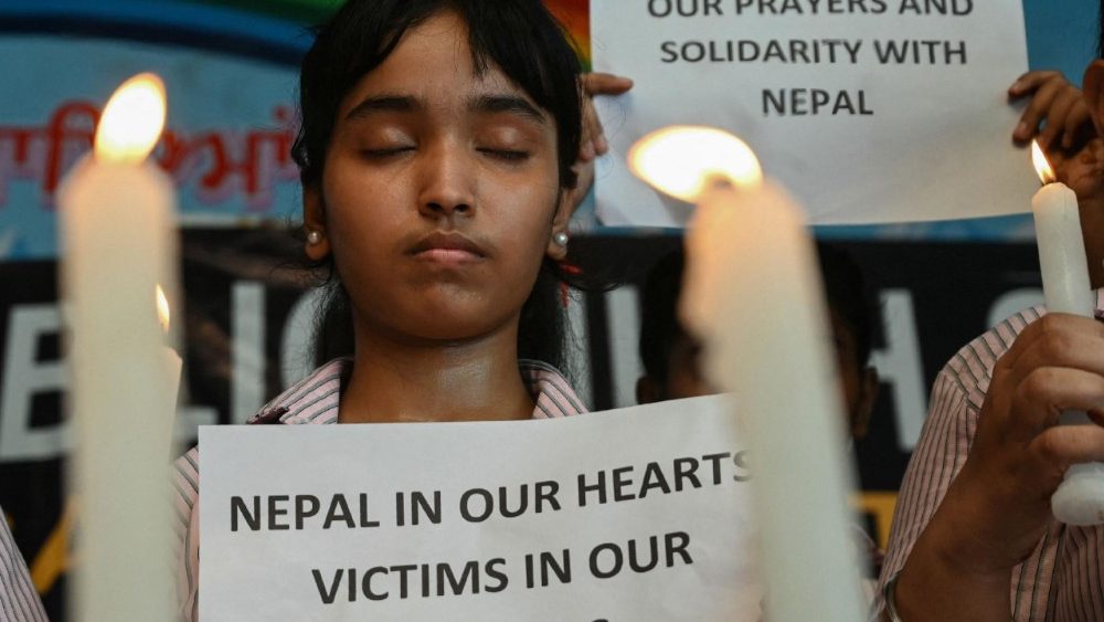 Um estudante segurando um cartaz presta homenagem às pessoas que morreram nas enchentes repentinas no Nepal, em Amritsar, em 29 de agosto de 2026. (Foto de Narinder NANU / AFP)
