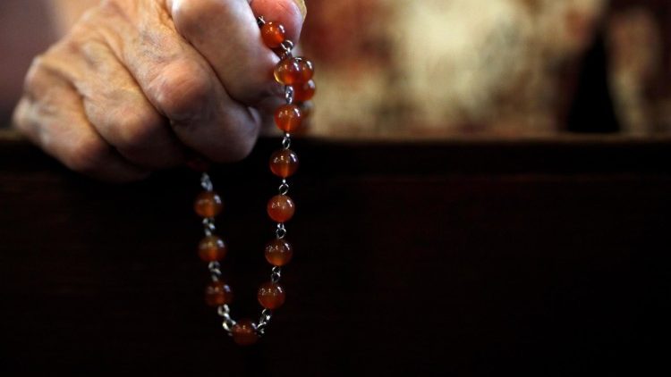 A Catholic faithful holds a rosary at Mass in Bangkok