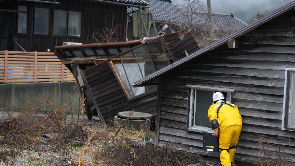Uma equipe de resgate procura pessoas desaparecidas em um prédio desabado na cidade de Monzen, cidade de Wajima, província de Ishikawa. EPA/FRANCK ROBICHON