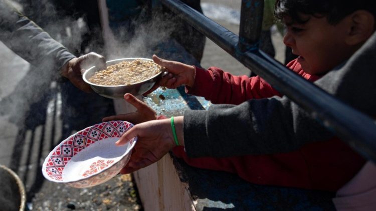 Bambini in fila per la distribuzione del cibo a Gaza