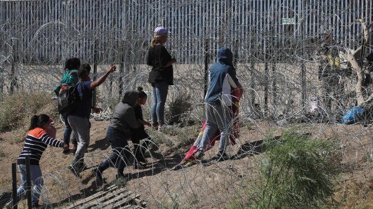 Los migrantes llegan cerca del muro fronterizo de Estados Unidos en México.