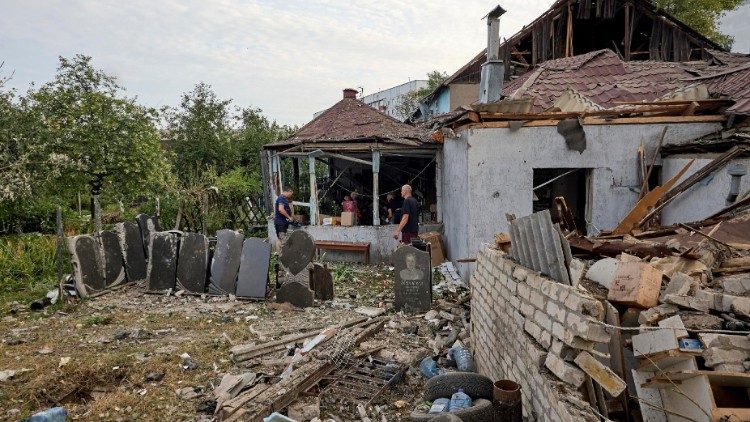 Policiais ucranianos e moradores locais verificam o local do ataque com foguete russo na cidade de Chuhuiv, na região de Kharkiv, nordeste da Ucrânia, em 19 de julho de 2024. Pelo menos nove pessoas ficaram feridas, incluindo uma criança, depois que um foguete russo atingiu Chuhuiv, de acordo com o chefe da Administração Militar de Kharkiv, Oleg Synegubov. EPA/SERGEY KOZLOV