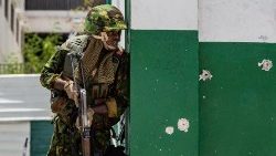 A Kenyan police officer stands guard after a gang attack on the Haitian PM's motorcade in July
