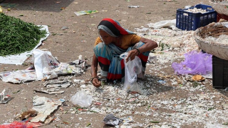 A woman looks for food scraps, India