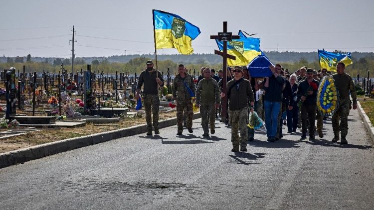 Parentes, amigos e camaradas do falecido militar ucraniano Maksym Kudrin, indicativo de chamada 'Rys' (Lince), comparecem à sua cerimônia fúnebre em um cemitério em Kharkiv, nordeste da Ucrânia, em 30 de setembro de 2024, em meio à invasão russa. Maksym Kudrin era um oficial que retornou à Ucrânia do exterior no início da invasão russa para se juntar à defesa territorial das Forças Armadas da Ucrânia (AFU). Ele foi morto em ação na direção de Kupiansk, na região de Kharkiv. EPA/SERGEY KOZLOV