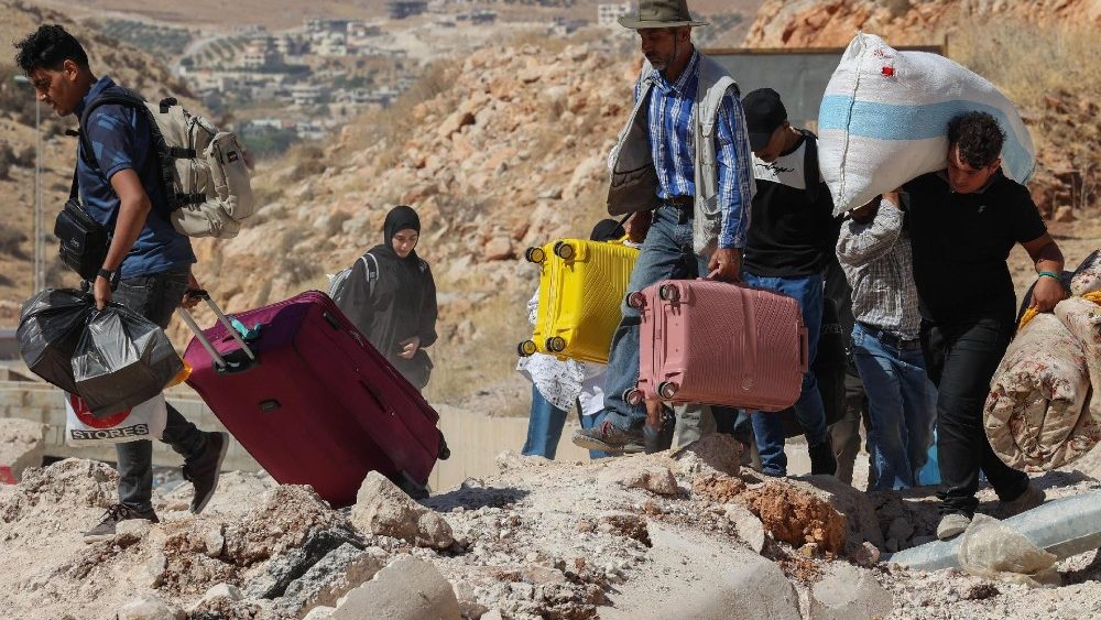 Famiglie in fuga dal Libano verso la Siria